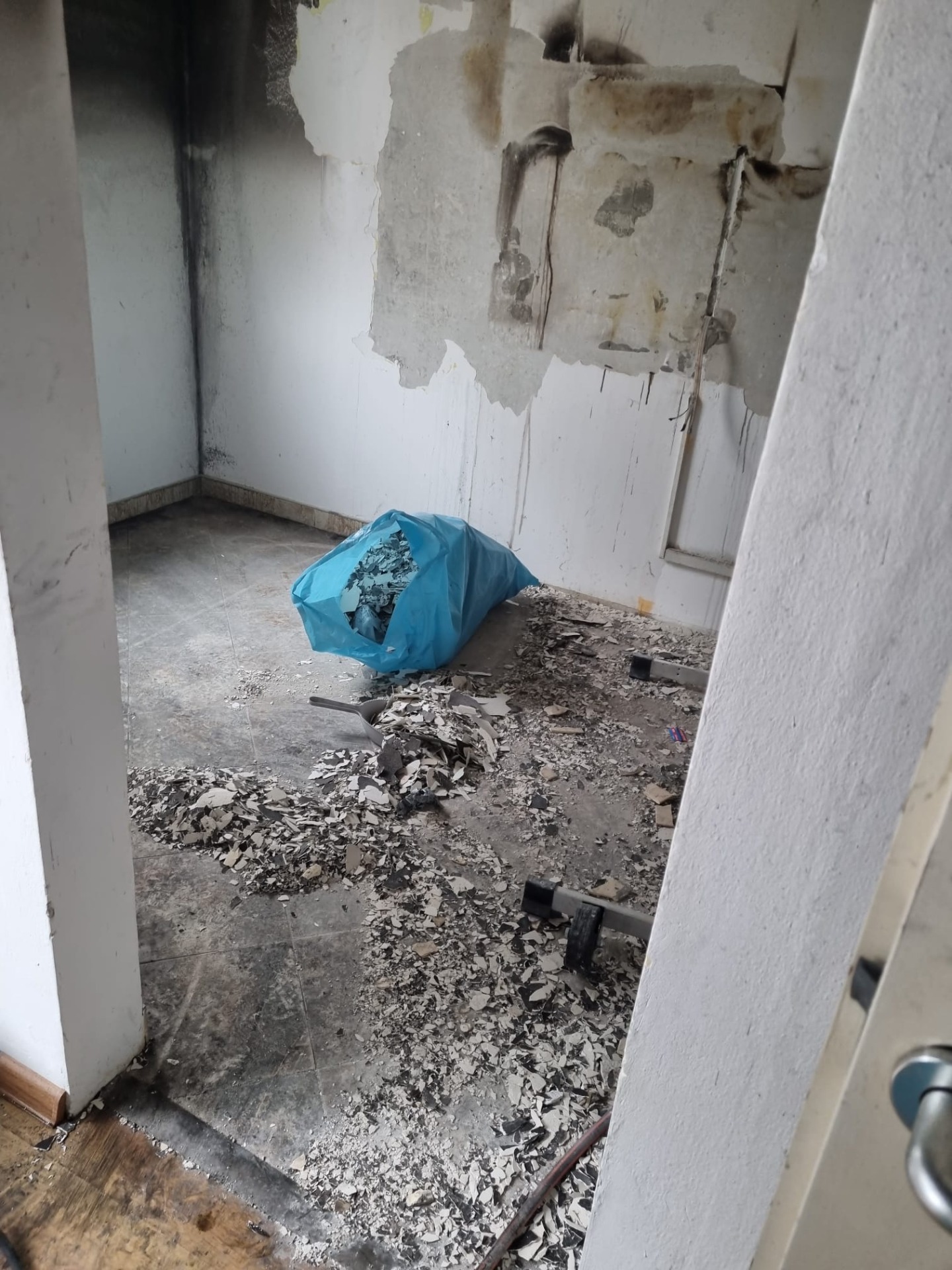Interiér po požáru s poškozenými stěnami a odkrytými částmi konstrukce